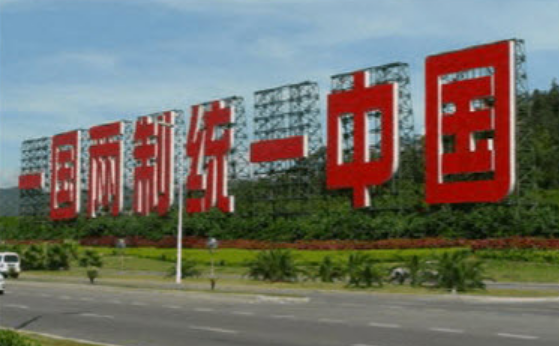 王同学到厦门环岛路游玩，看见一个巨幅标语（如右图）对同伴说：“毛泽东的这个伟大构想太有创造性了，他为